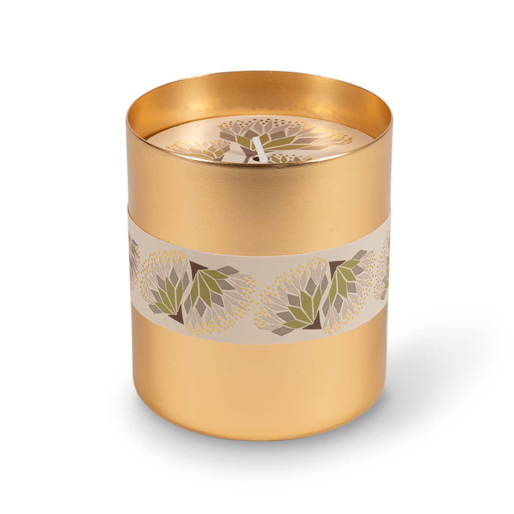 A cylindrical gold metal candle tin with a cream band decorated with green and white floral motifs, shown on a clean white background.