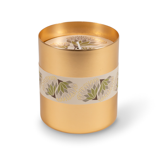 A cylindrical gold metal candle tin with a cream band decorated with green and white floral motifs, shown on a clean white background.